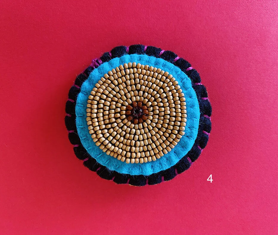 Photo of option 4: a colorful hand-sewn & beaded felt brooch of various skin tones that looks like tatas.
