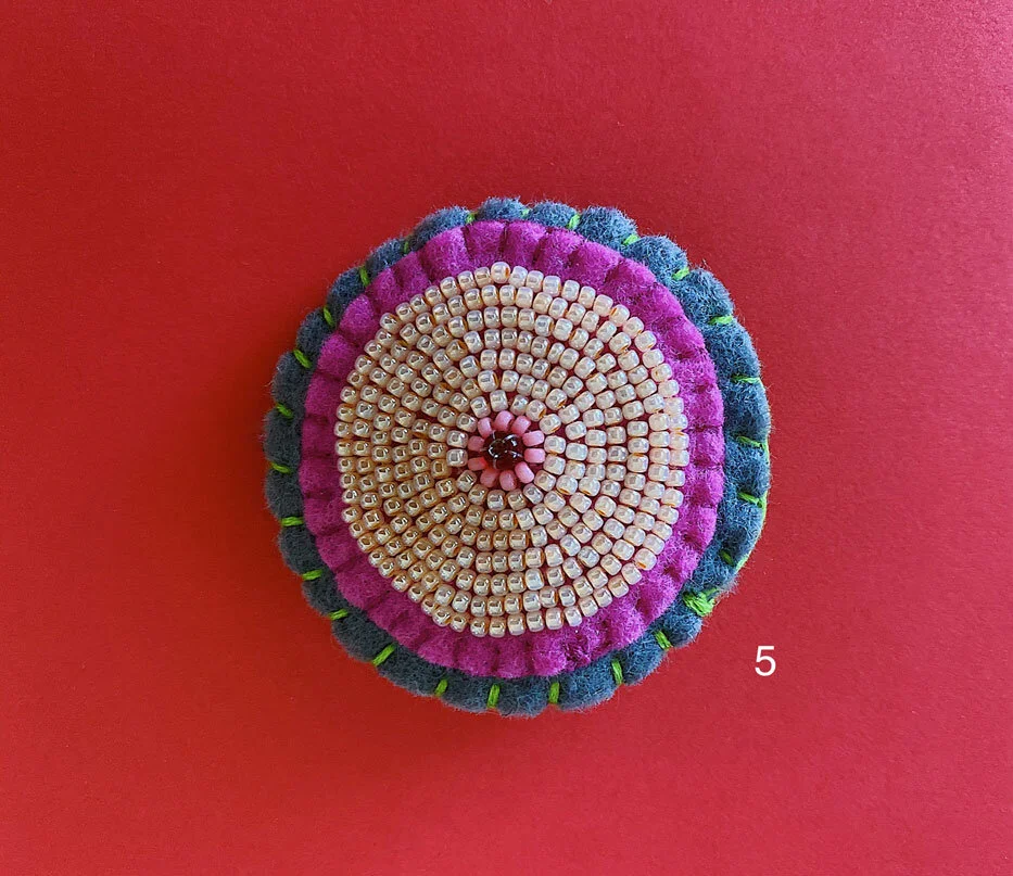Photo of option 5: a colorful hand-sewn & beaded felt brooch of various skin tones that looks like tatas.