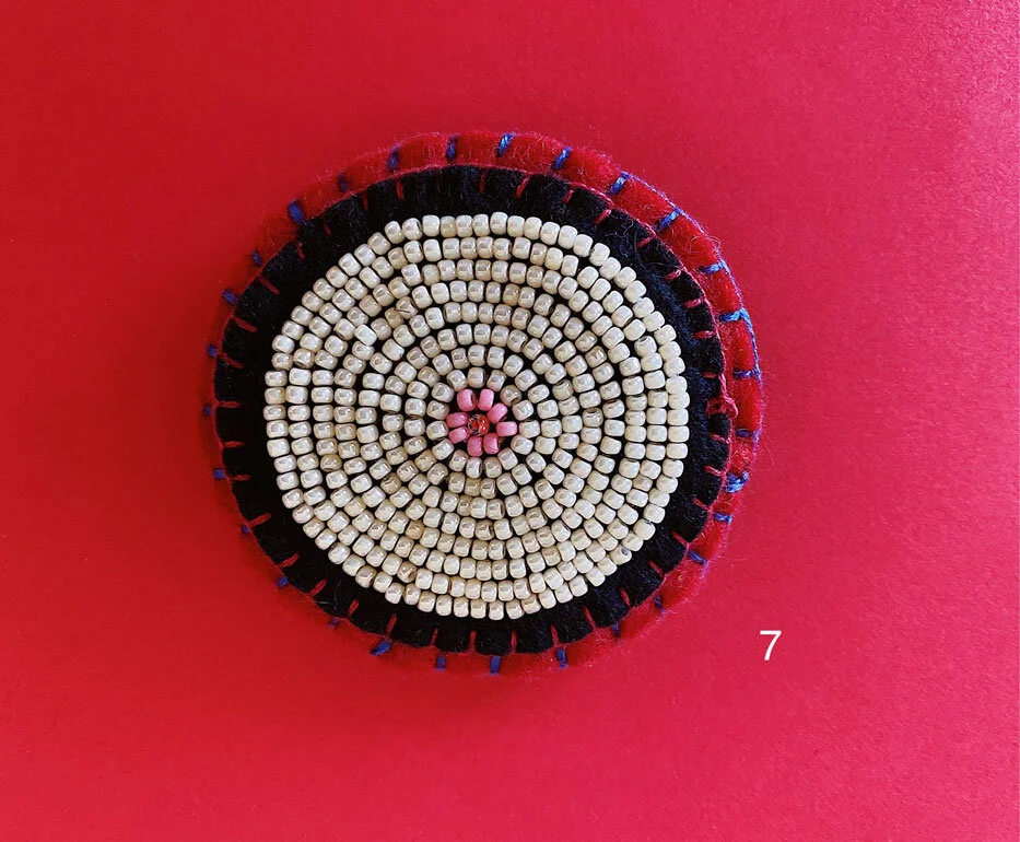 Photo of option 7: a colorful hand-sewn & beaded felt brooch of various skin tones that looks like tatas.