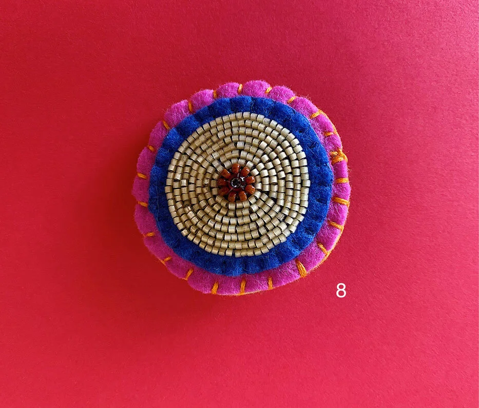 Photo of option 8: a colorful hand-sewn & beaded felt brooch of various skin tones that looks like tatas.