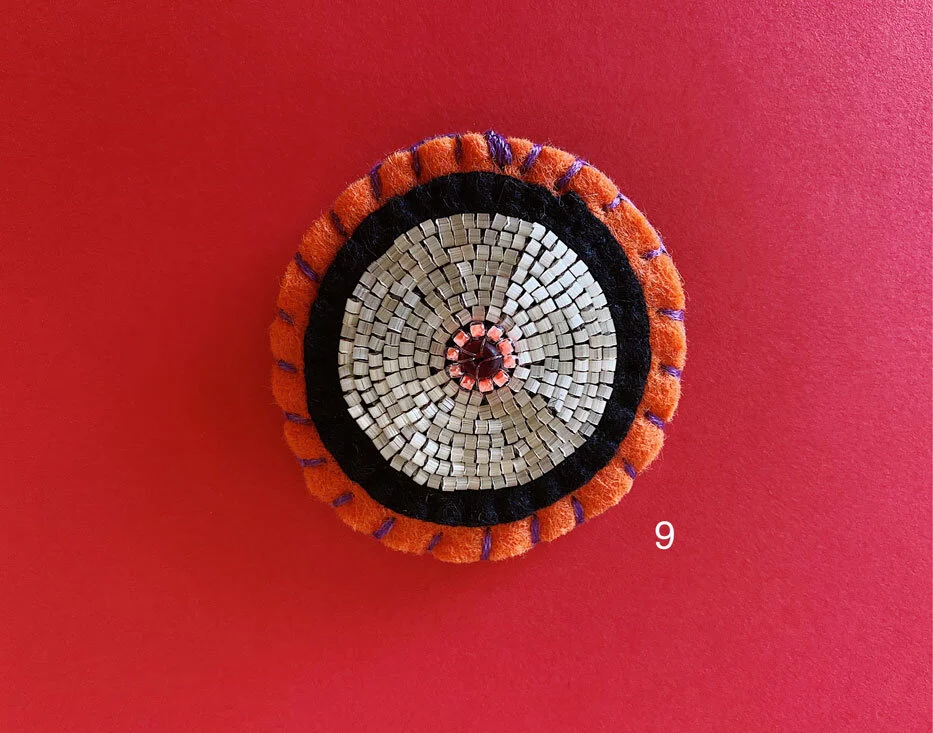 Photo of option 9: a colorful hand-sewn & beaded felt brooch of various skin tones that looks like tatas.