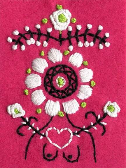 Detail photo of colorful hand-embroidered goddess with a white flower head on a bright pink felt background.