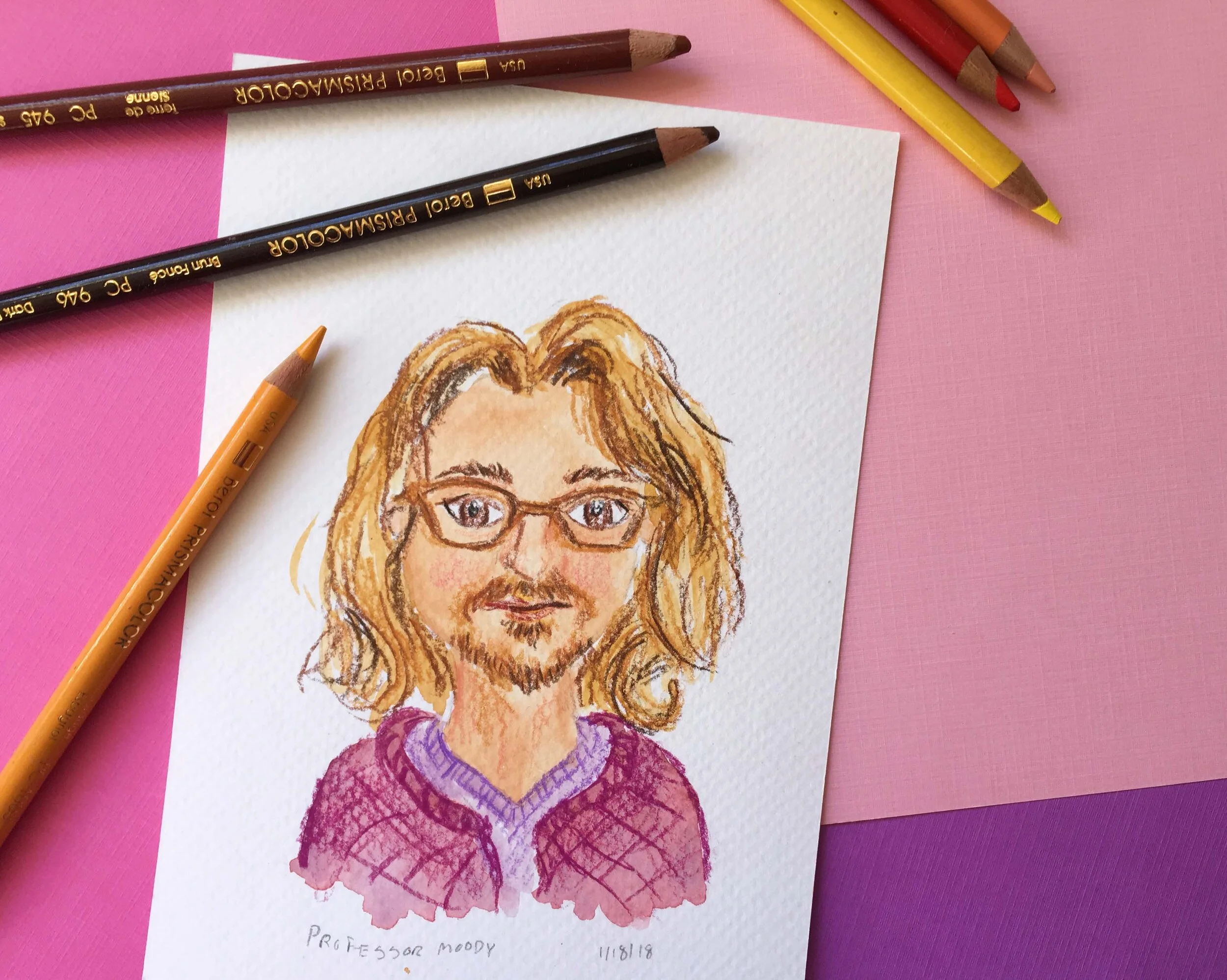 Photo of a portrait of a man using gouache & colored pencils surrounded by art supplies on a pink & purple background.