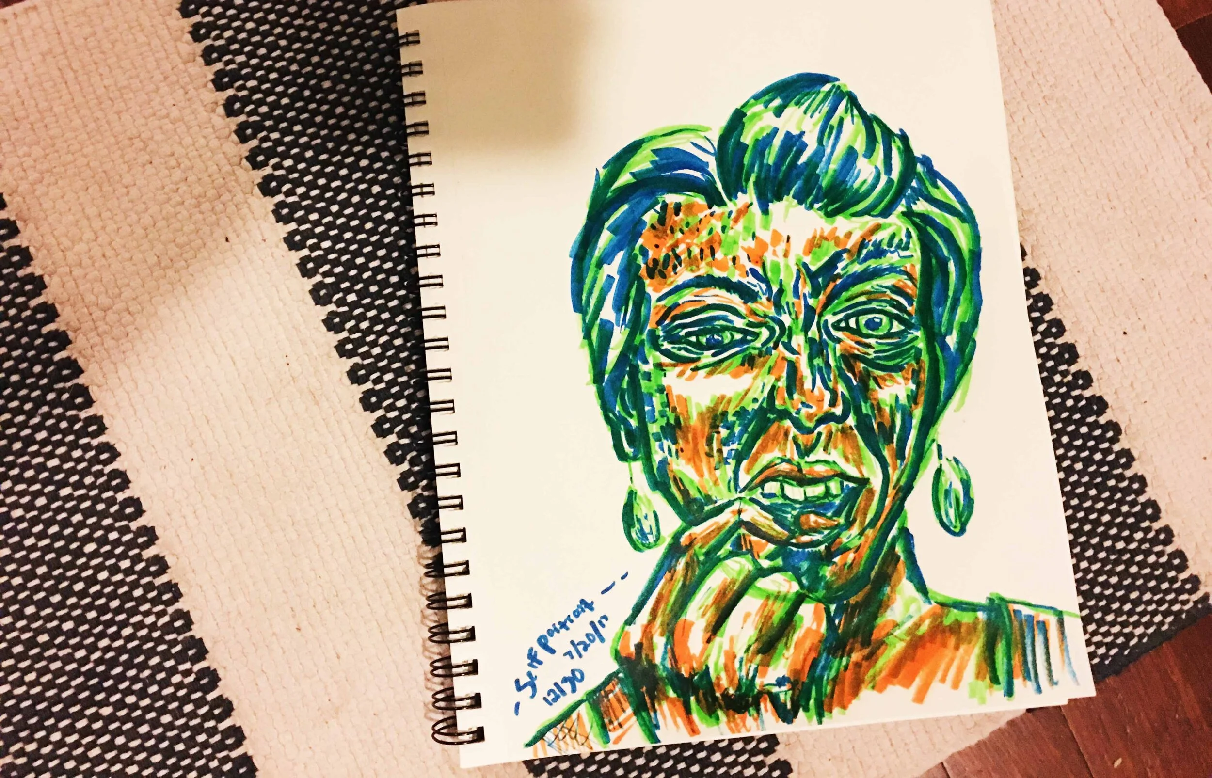 Day 12: photo of a self-portrait eating a snack surrounded by art supplies on a table.