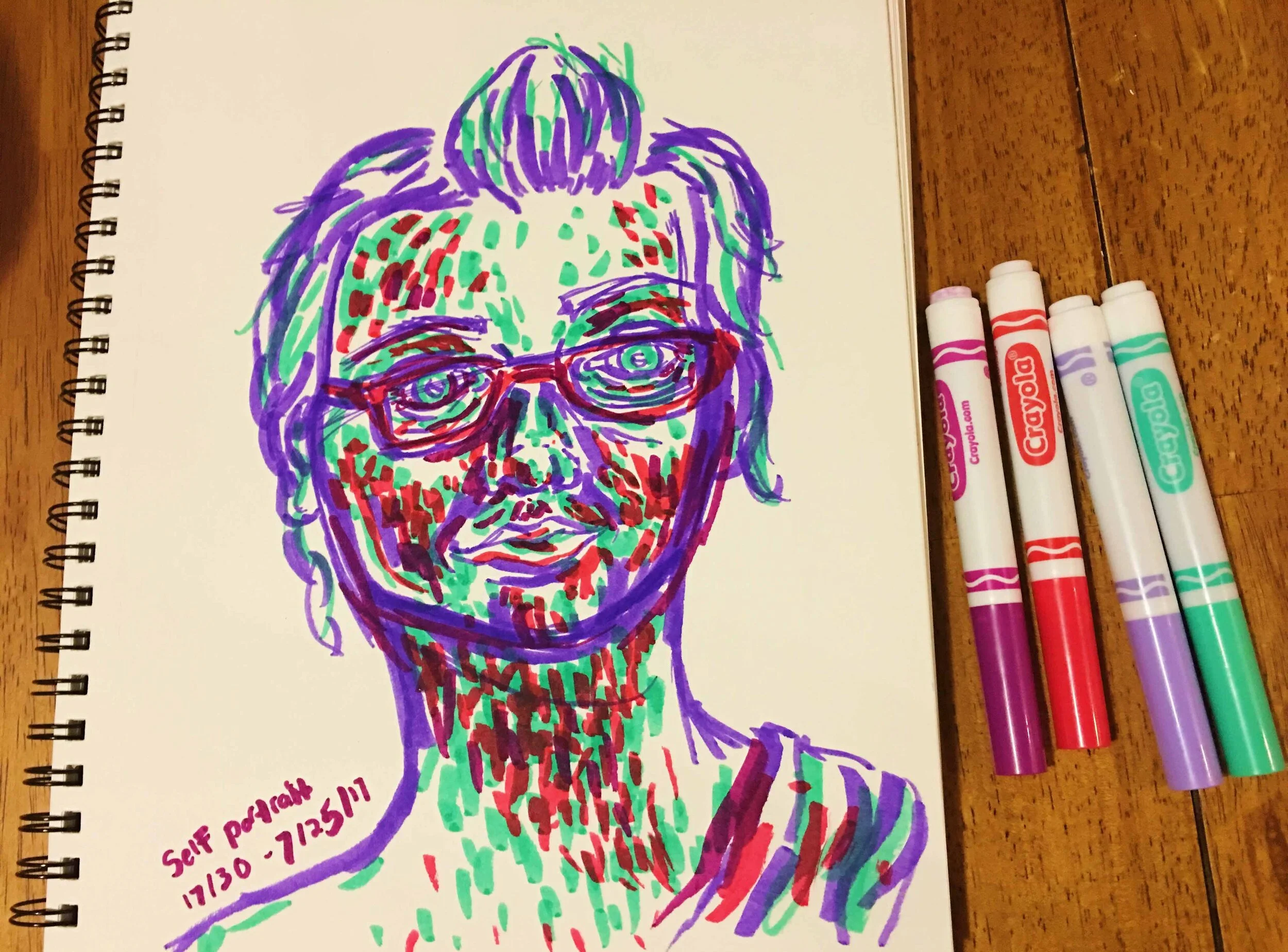 Day 17: photo of a marker self-portrait wearing glasses surrounded by art supplies on a table.