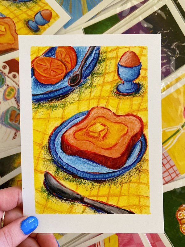 Detail of a breakfast scene with toast, fruit and egg on a yellow tablecloth. Print measures 5" by 7" & is on recycled stock.