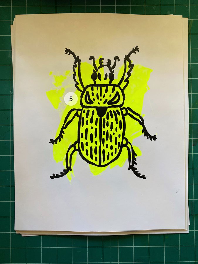 Overview of a hand made 11"x14" screen print of a beetle with a colorful neon yellow paint swipe background.