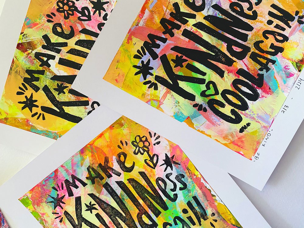 Group detail photo of lino cut prints with a hand-painted backing and text that reads "make kindness cool again".