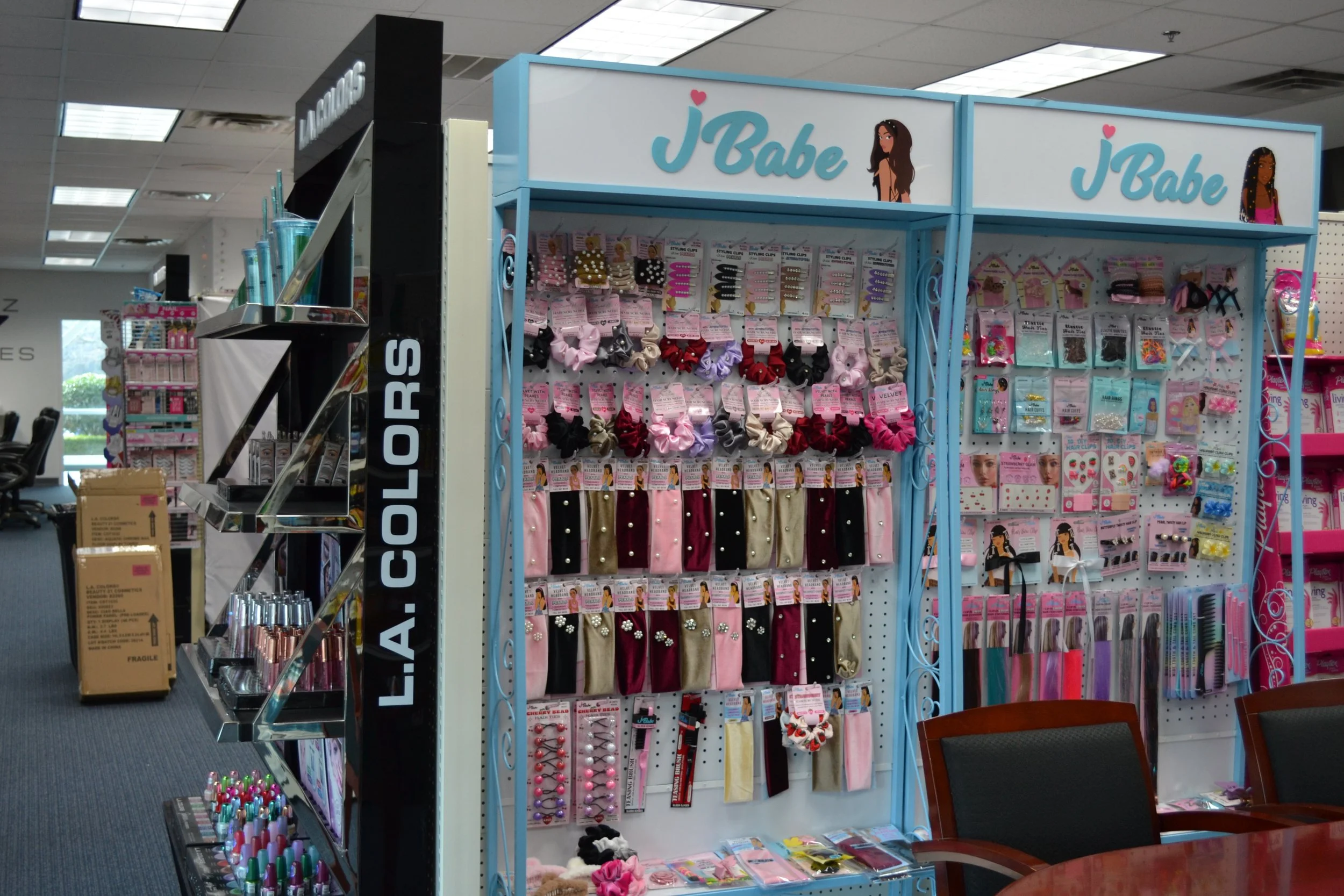 Display of hair accessories and jewelry at a store named j’Babe with pink, black, and gold bows, earrings, and hair clips.