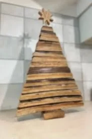 A Christmas tree made from stacked wooden pallets with a star on top.