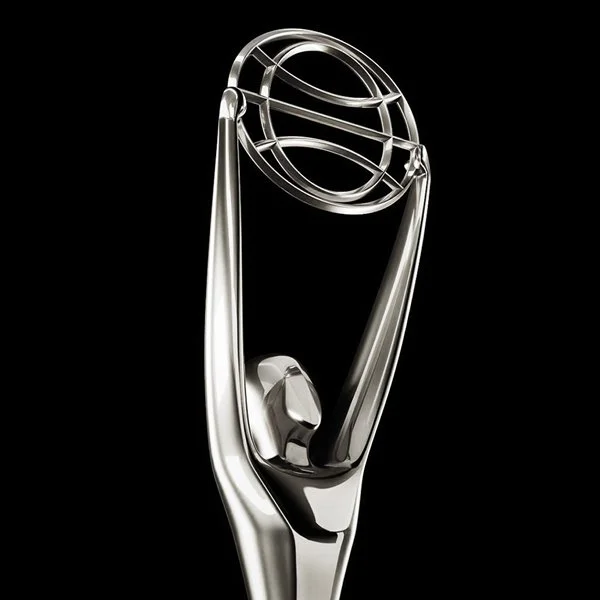 Silver trophy with abstract human figure holding a globe on a black background.