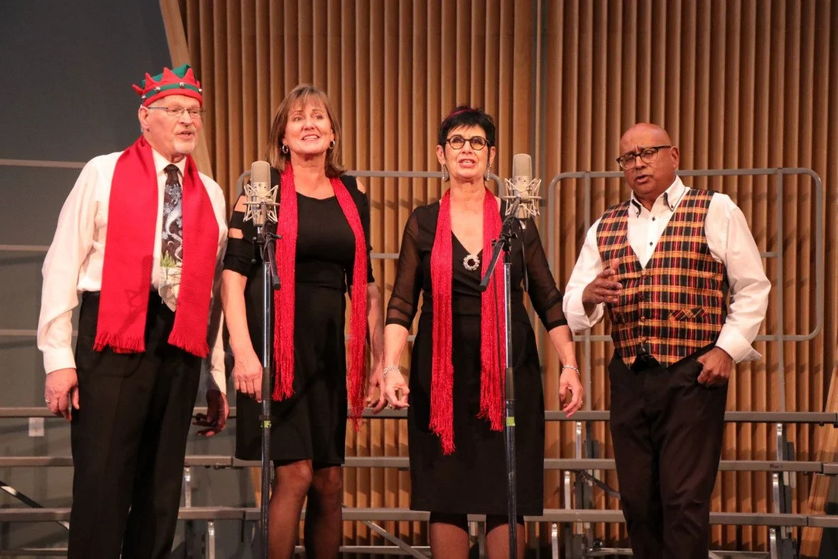 Collage, a two-man and two-woman barbershop quartet, performing onstage in holiday-themed attire.