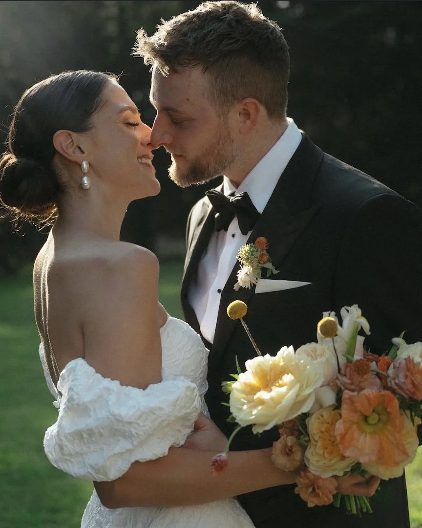 bride and groom share a kiss outdoors