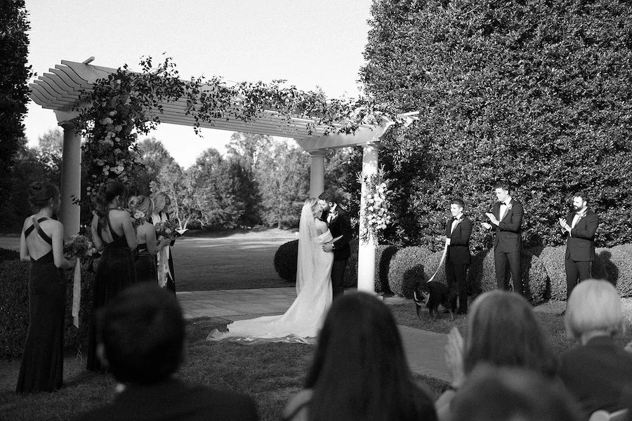 bride and groom share a first kiss during their wedding ceremony at boxwood estate
