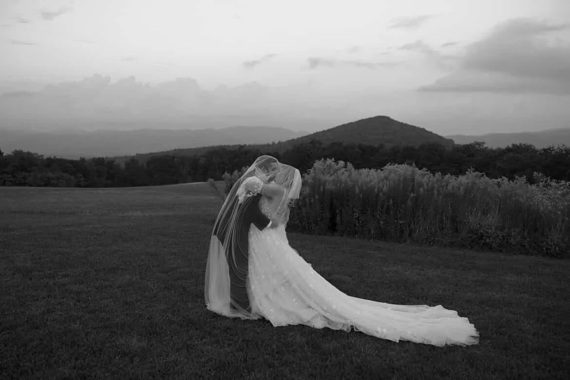 bride and groom share a kiss on the mountain top