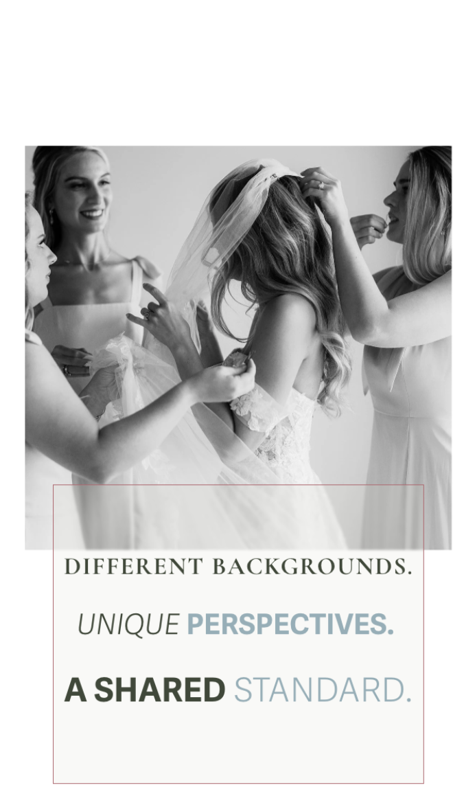 Black and white photo of a bride getting ready with her bridesmaids, three women helping her with her wedding dress and veil.