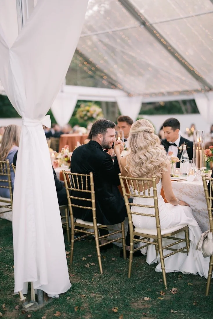 bride and groom seated at the table for their outdoor reception