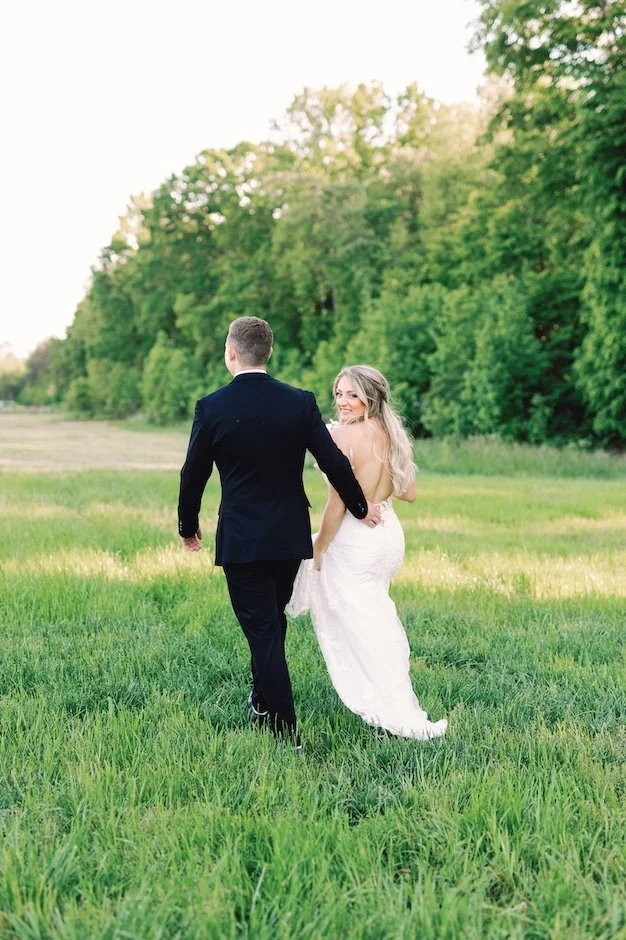 bride and groom walking through a field during their remote wedding at fields of skycrest in cleveland ga