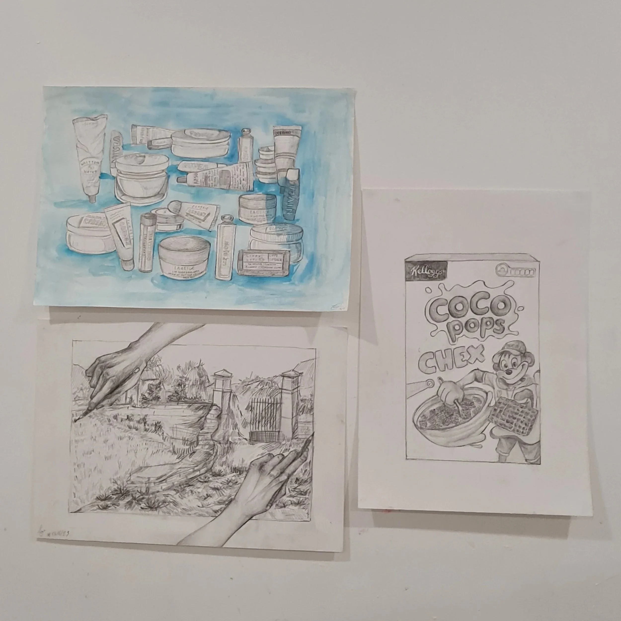 A hand-drawn illustration of various skincare and cosmetic products, including creams and tubes, against a blue background. There is also a partially colored drawing of a grocery list or sign with the words 'Coco Pops' and a cartoon character at the 