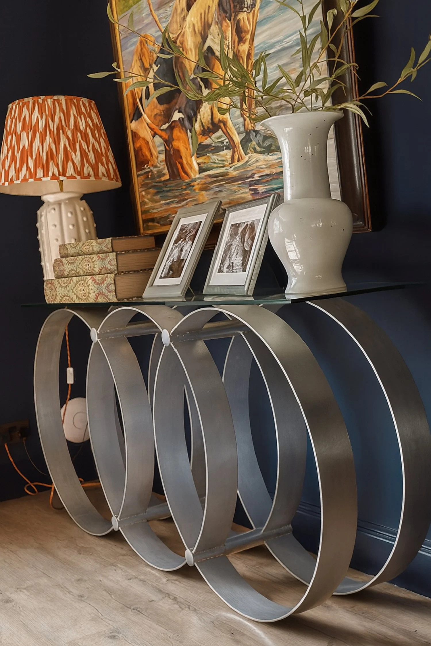 Circular metal console table with glass top