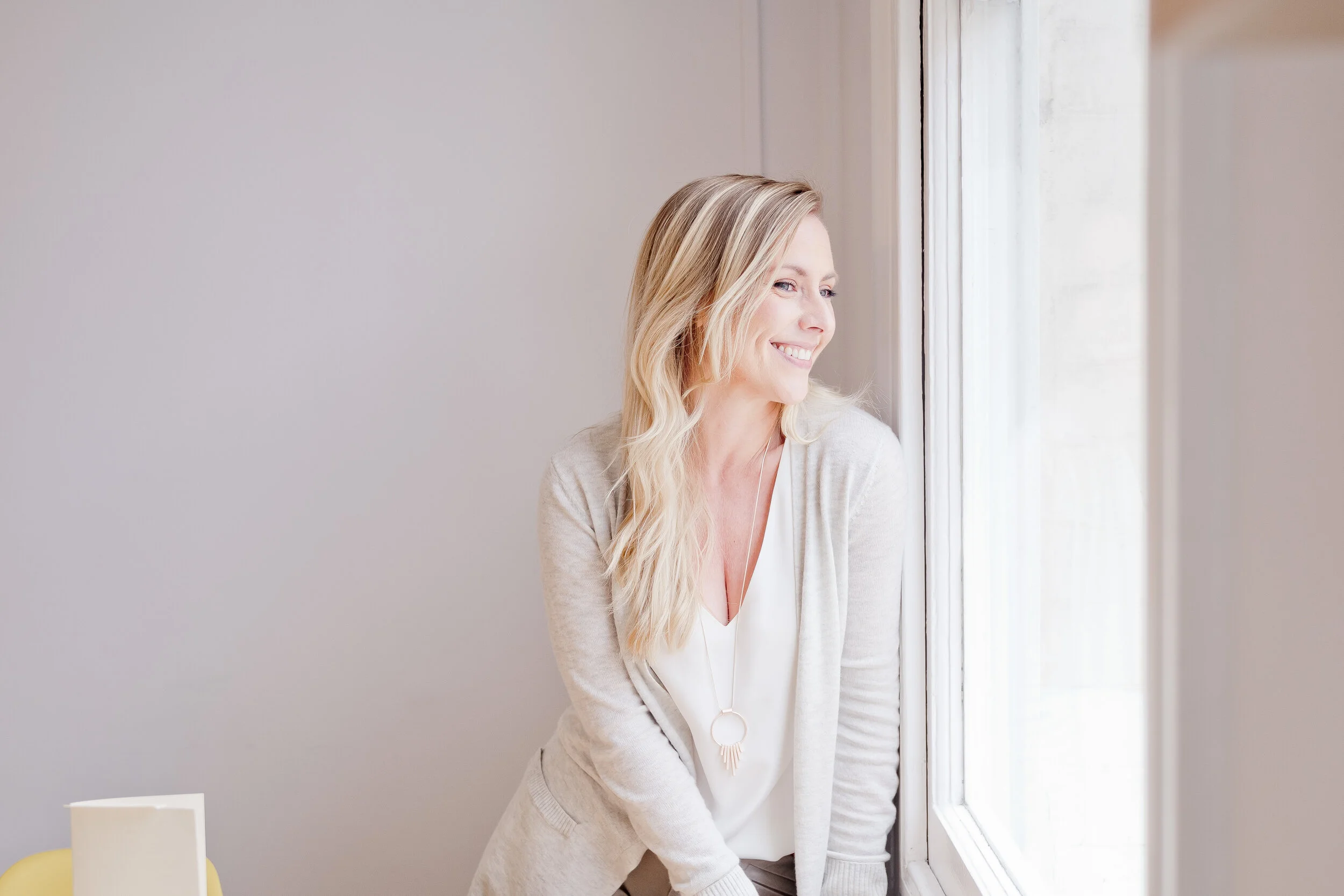 Image of Ally Murphy looking out of a window and smiling.