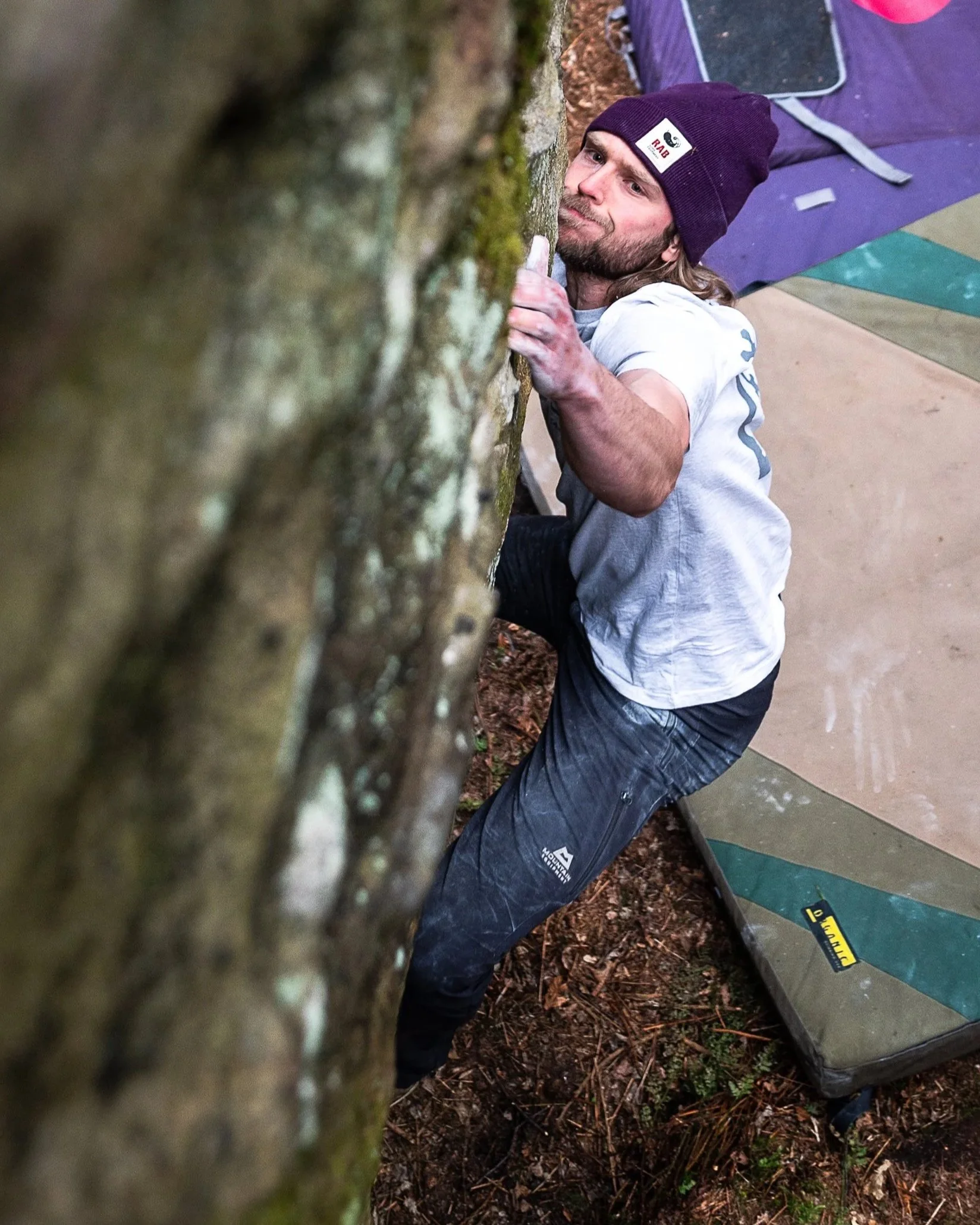 Climber at the crag using liquid chalk. Holding onto rock with hand covered in chalk.