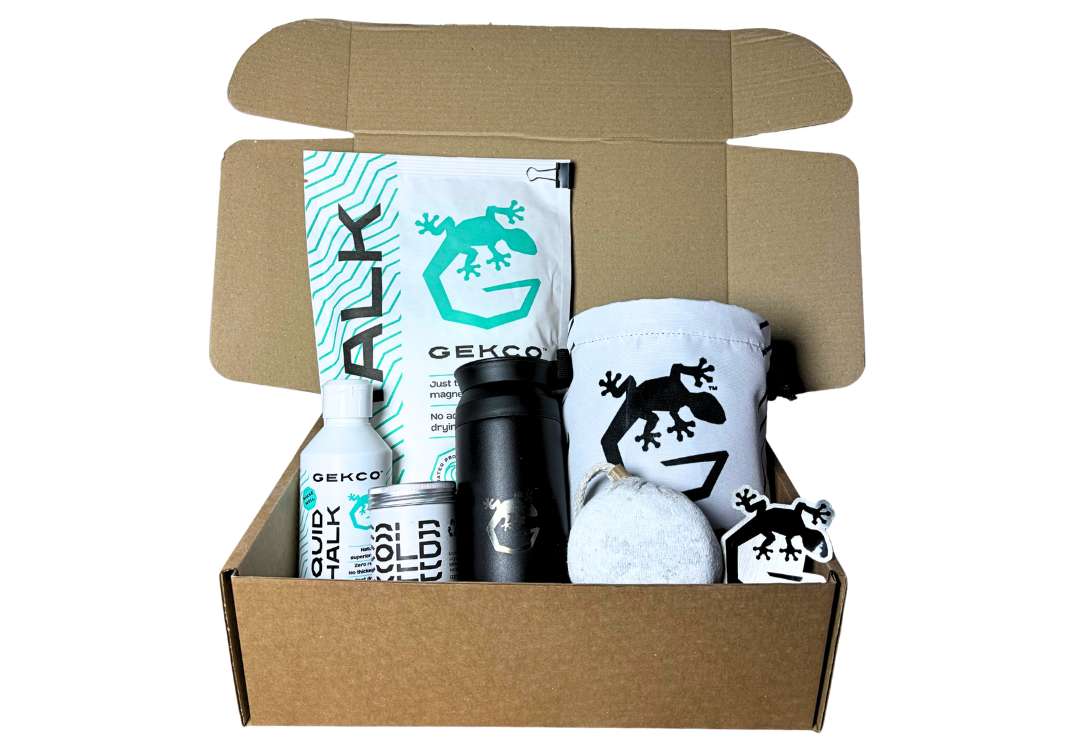 A GEKCO gift set with a chalk bag, flask, loose chalk, liquid chalk, chalk ball, COLD, and stickers.