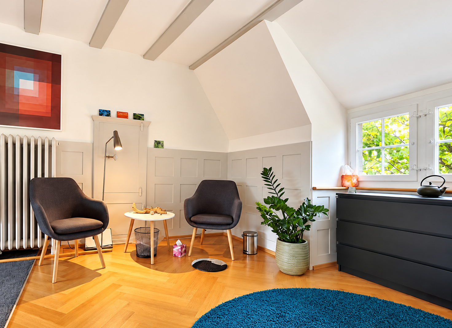 Heller Praxisraum von Roger Lüthi - Körpertherapie im Zentrum Frau & Familie in Baden mit Sitzecke und ruhiger Atmosphäre