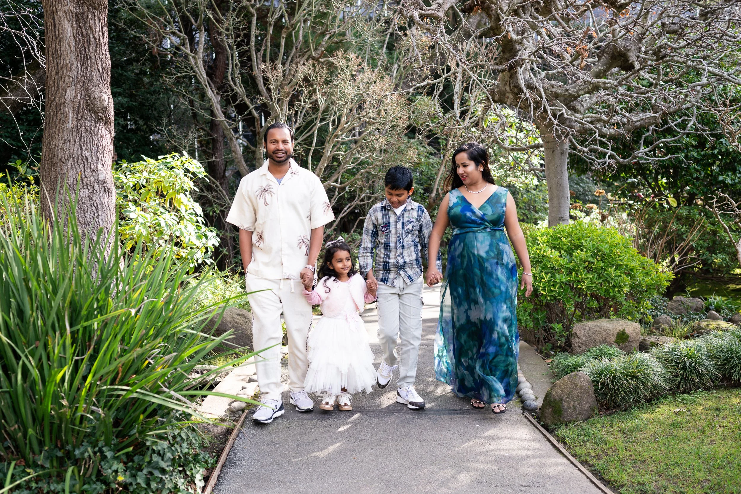 Parents stand together on a garden bridge during a Give Light family photo session at the San Mateo Japanese Garden, emphasizing connection, presence, and simplicity.