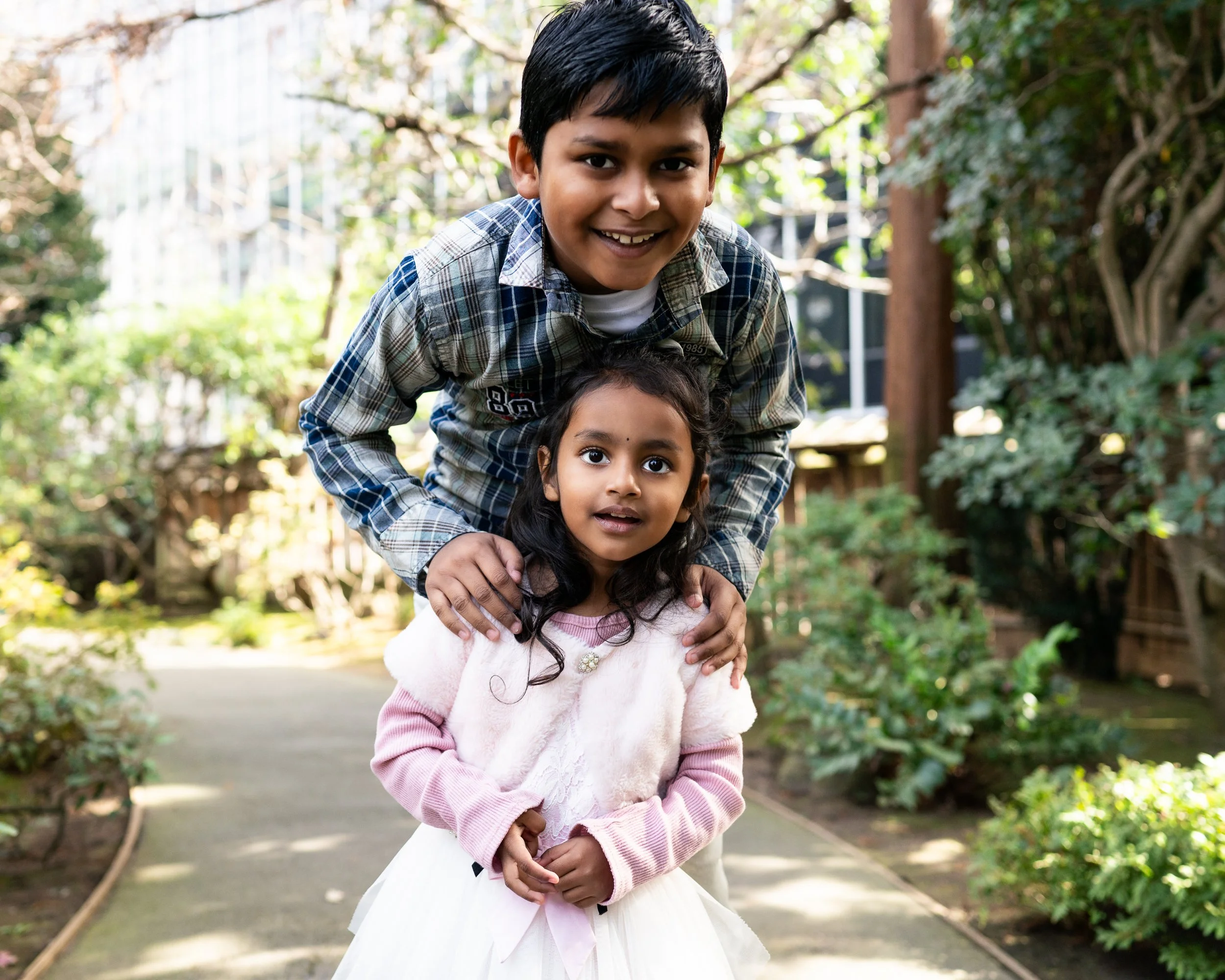 Siblings share a playful, tender moment during a Give Light free family photography session in the Bay Area, photographed in natural light and a relaxed outdoor environment.