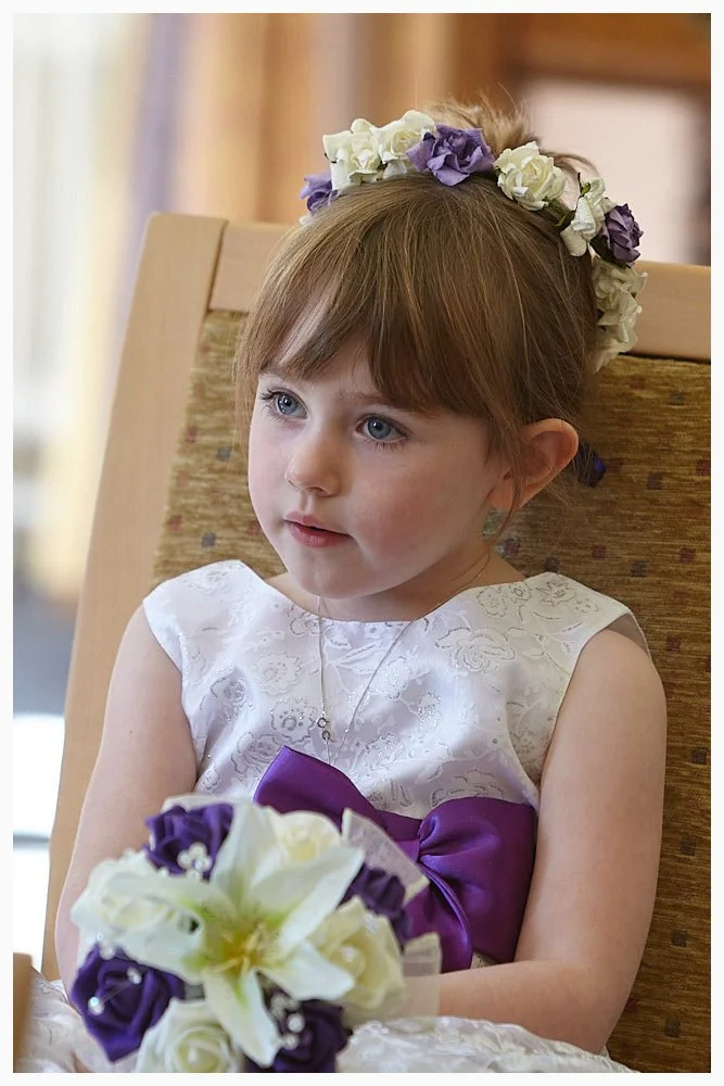 This flower girl pays great attention during her mum’s wedding ceremony