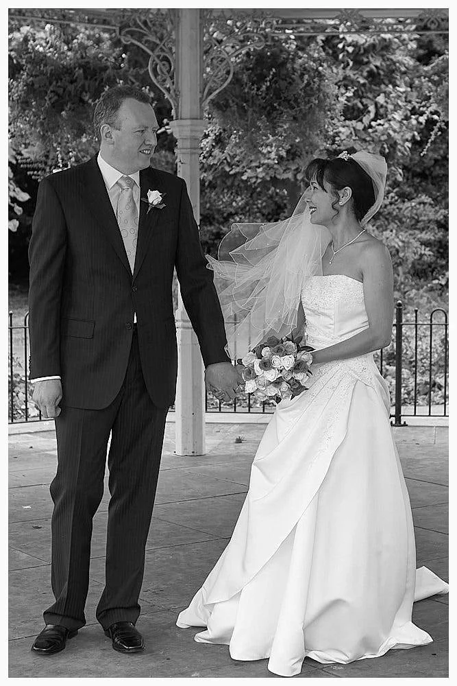 Bride and groom pose for a semi-formal photo at the bandstand in the park after their Basingstoke wedding