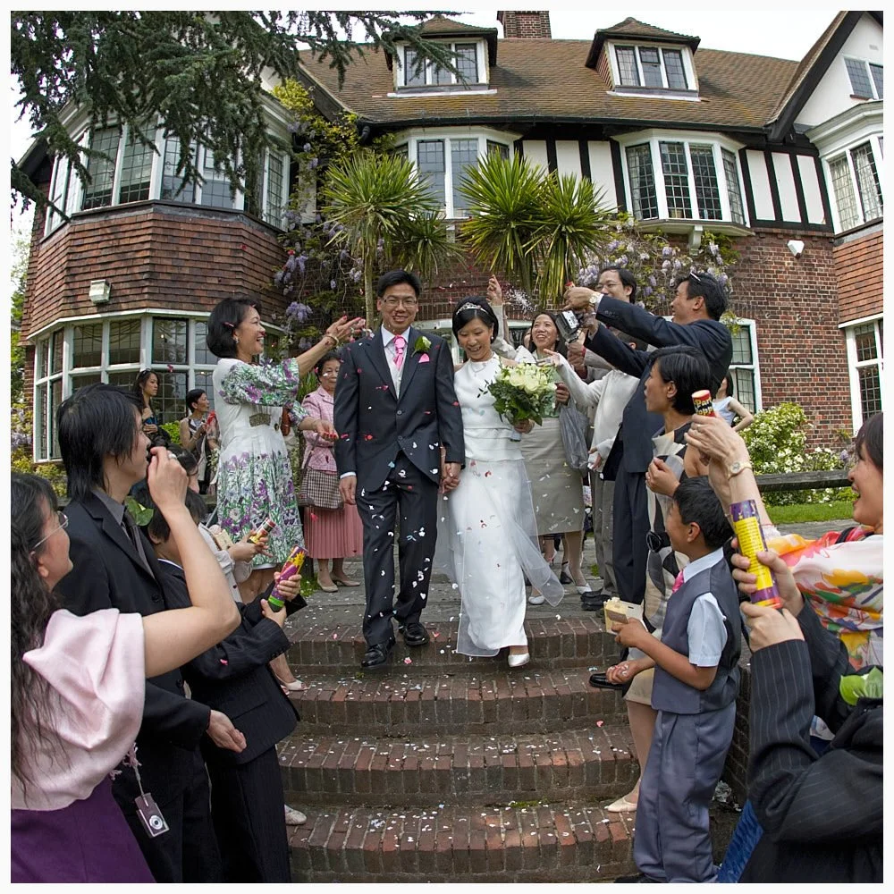 Guests throw confetti over the newly wed bride and groom at Weybridge Registry Office