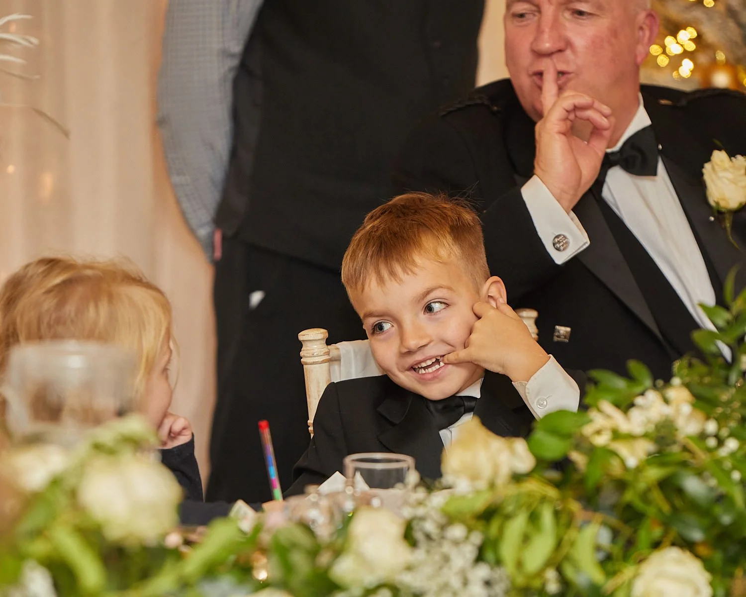 Pageboy smiles towards the flowergirl during wedding reception at The Mill House Hotel Swallowfield