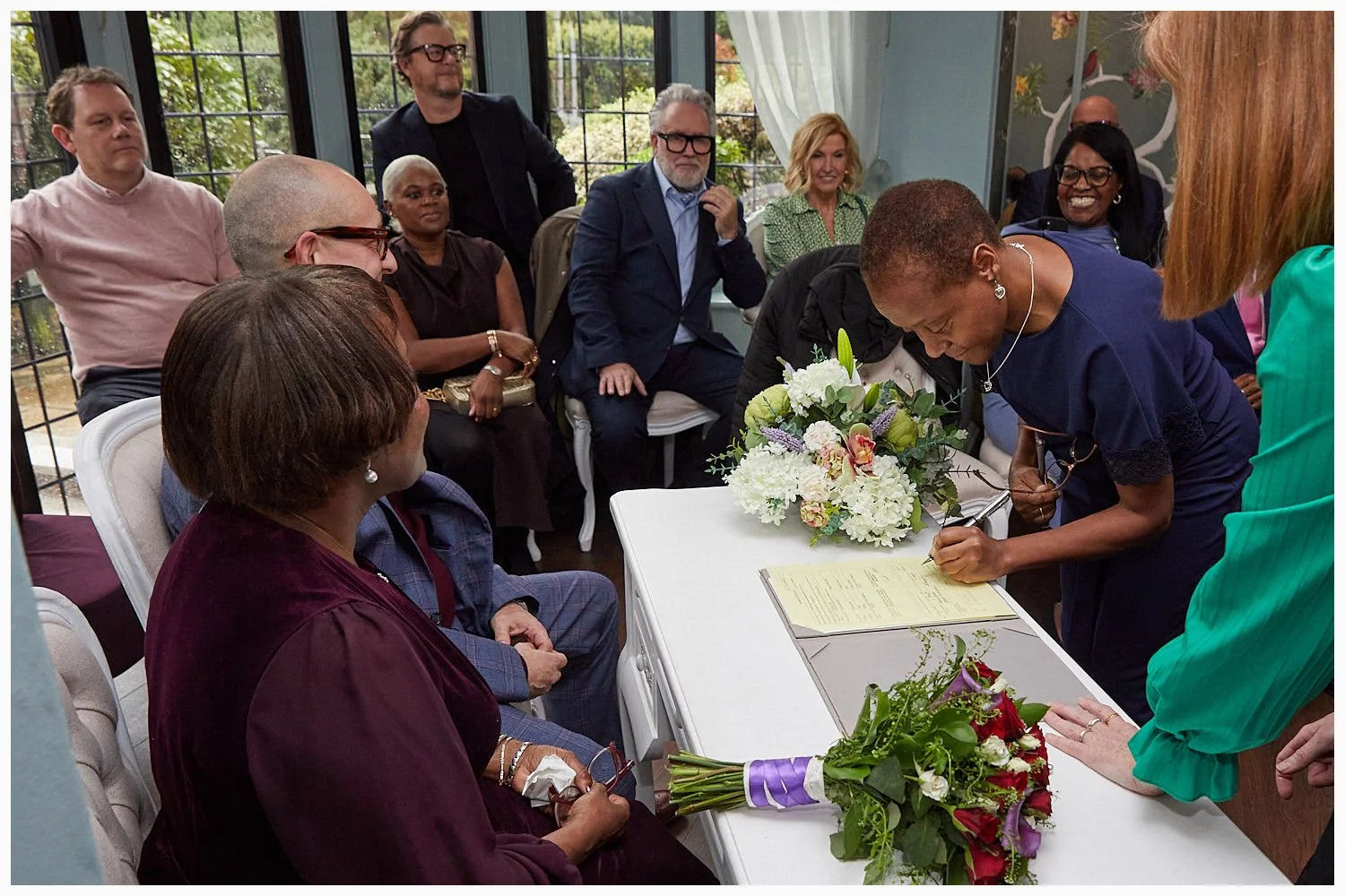 Guests sign the marriage schedule at the end of the wedding ceremony at Weybridge Registry Office