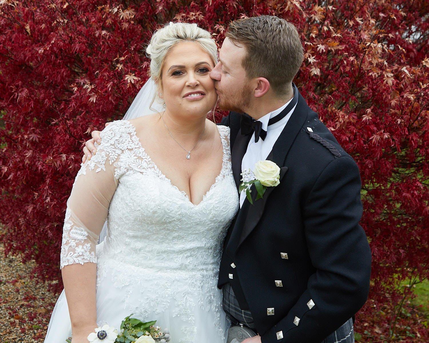 Bride and groom pose for a fun photo in the gardens at The Mill House Hotel Swallowfield after their marriage ceremony
