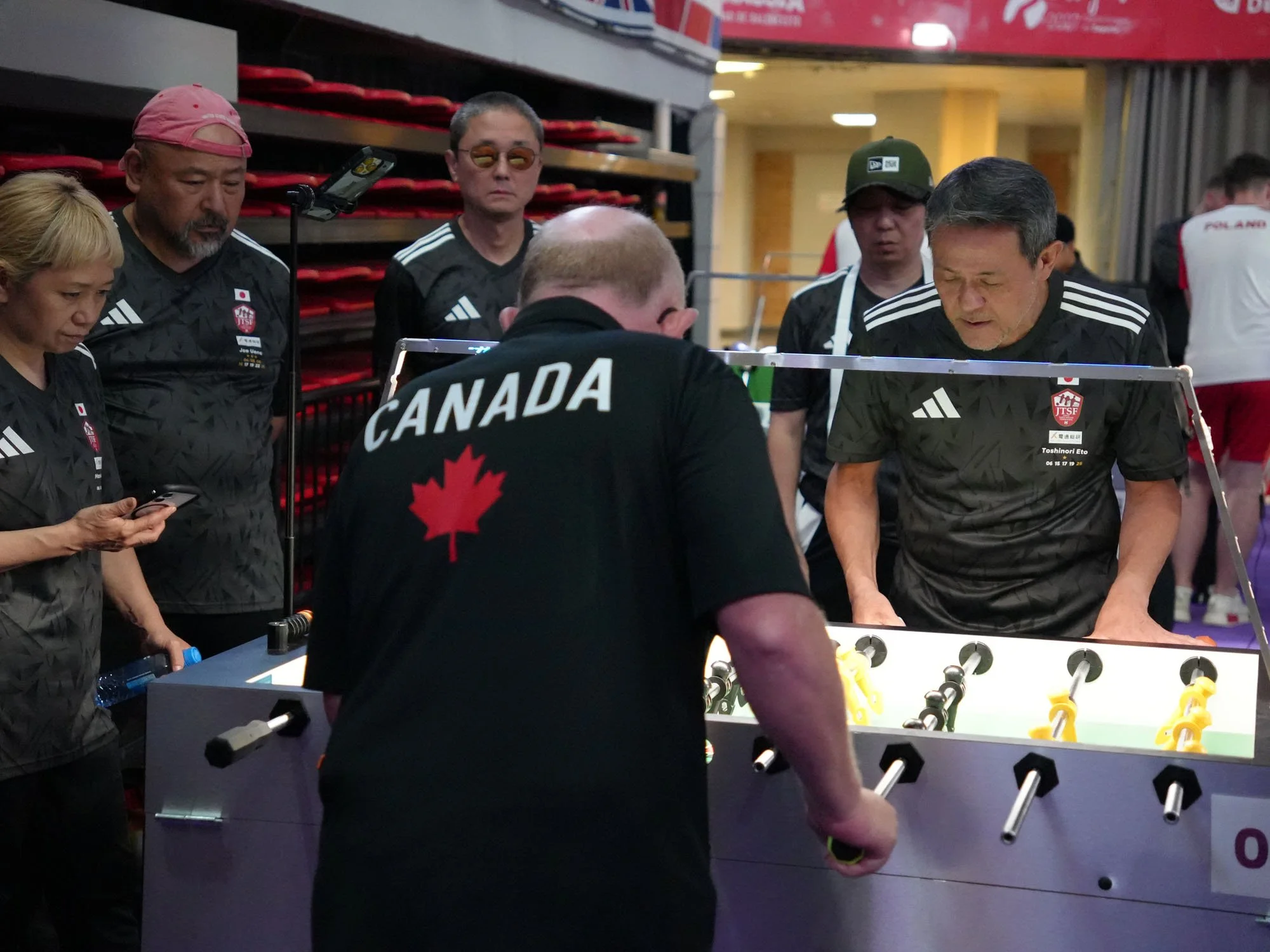 Japanese team members watch as Kent Farries plays Toshinori Eto in Qualification Round 3.