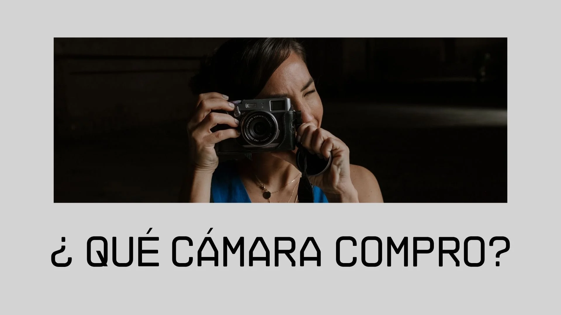 Mujer toma una foto con una cámara réflex en un ambiente oscuro.