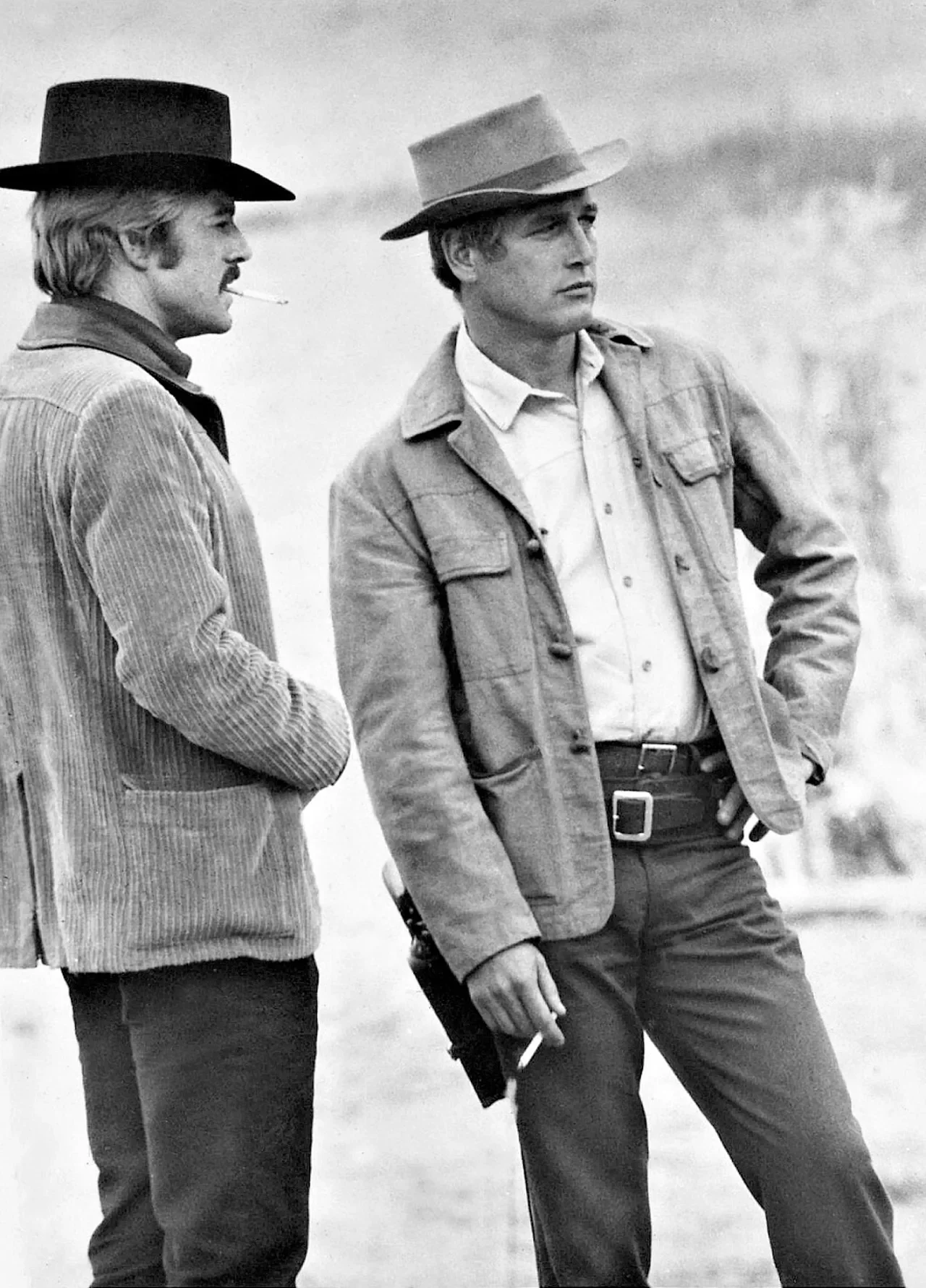 Two men in cowboy hats and jackets standing outdoors in a black and white photo.
