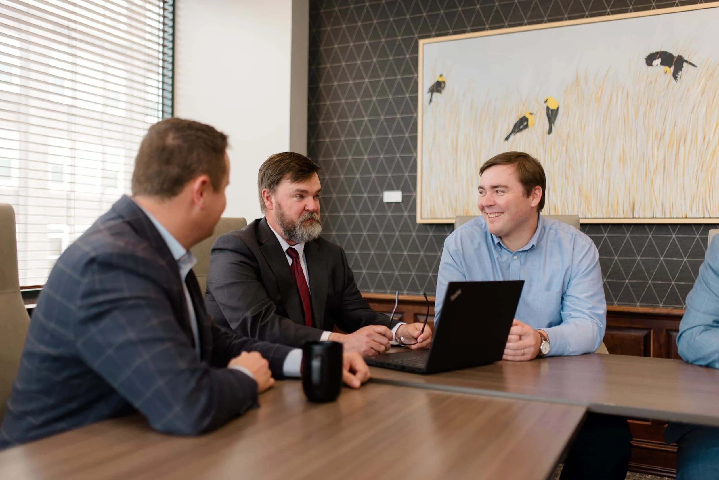 Tom Schartz and his colleagues talking in a conference room