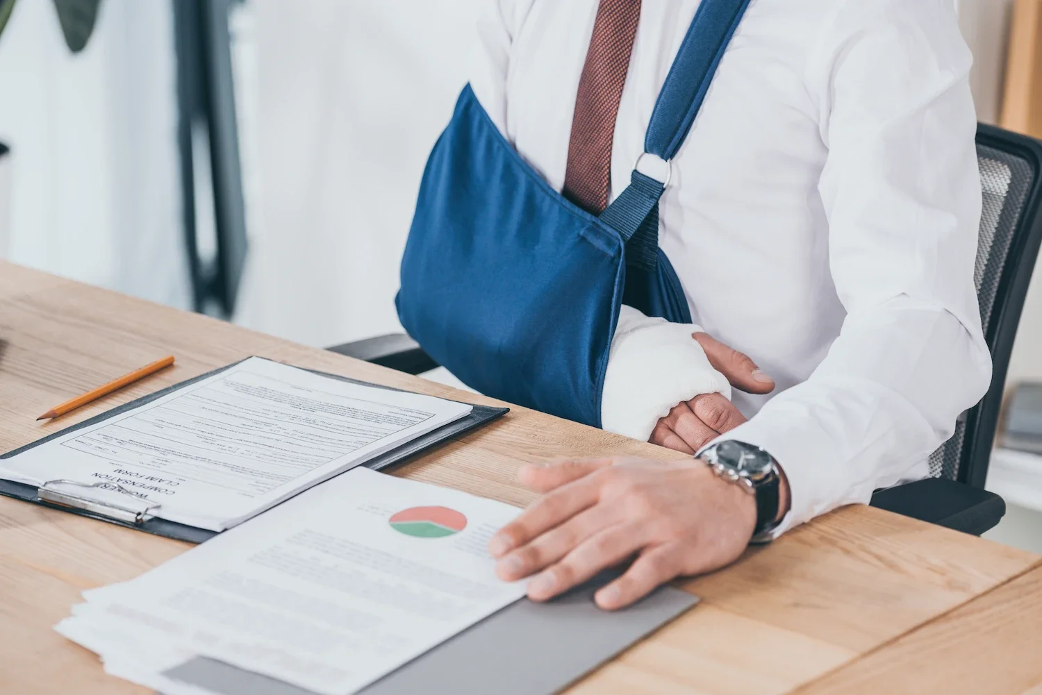 Person in sling looking over paperwork.