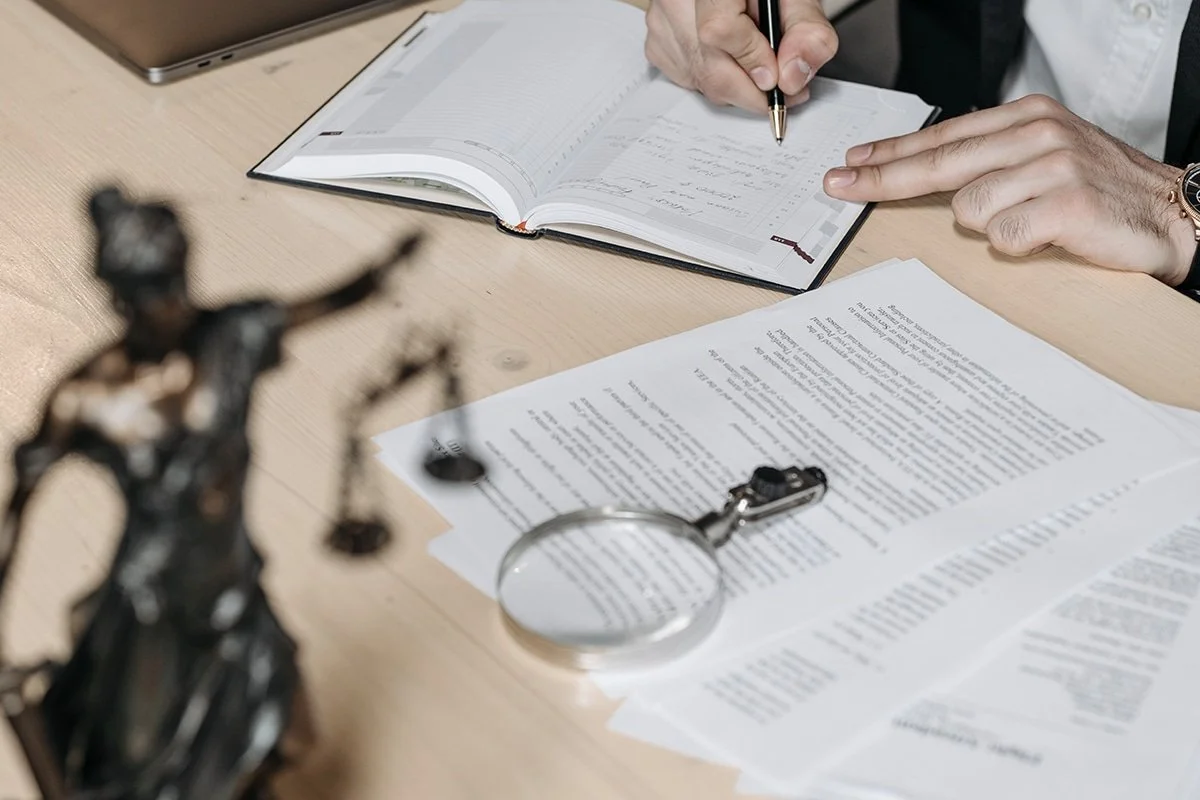 man writing in planner notebook