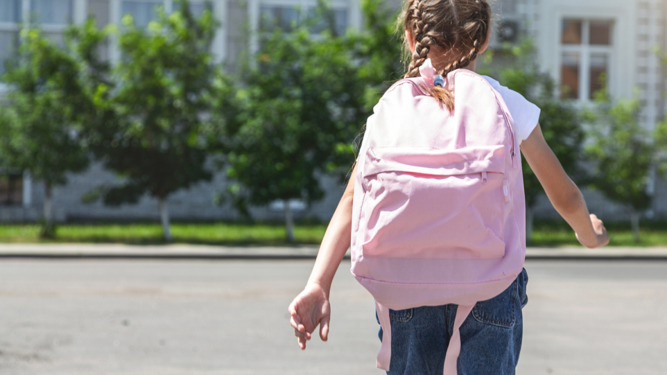 Picture of school-aged child walking with a pink backpack
