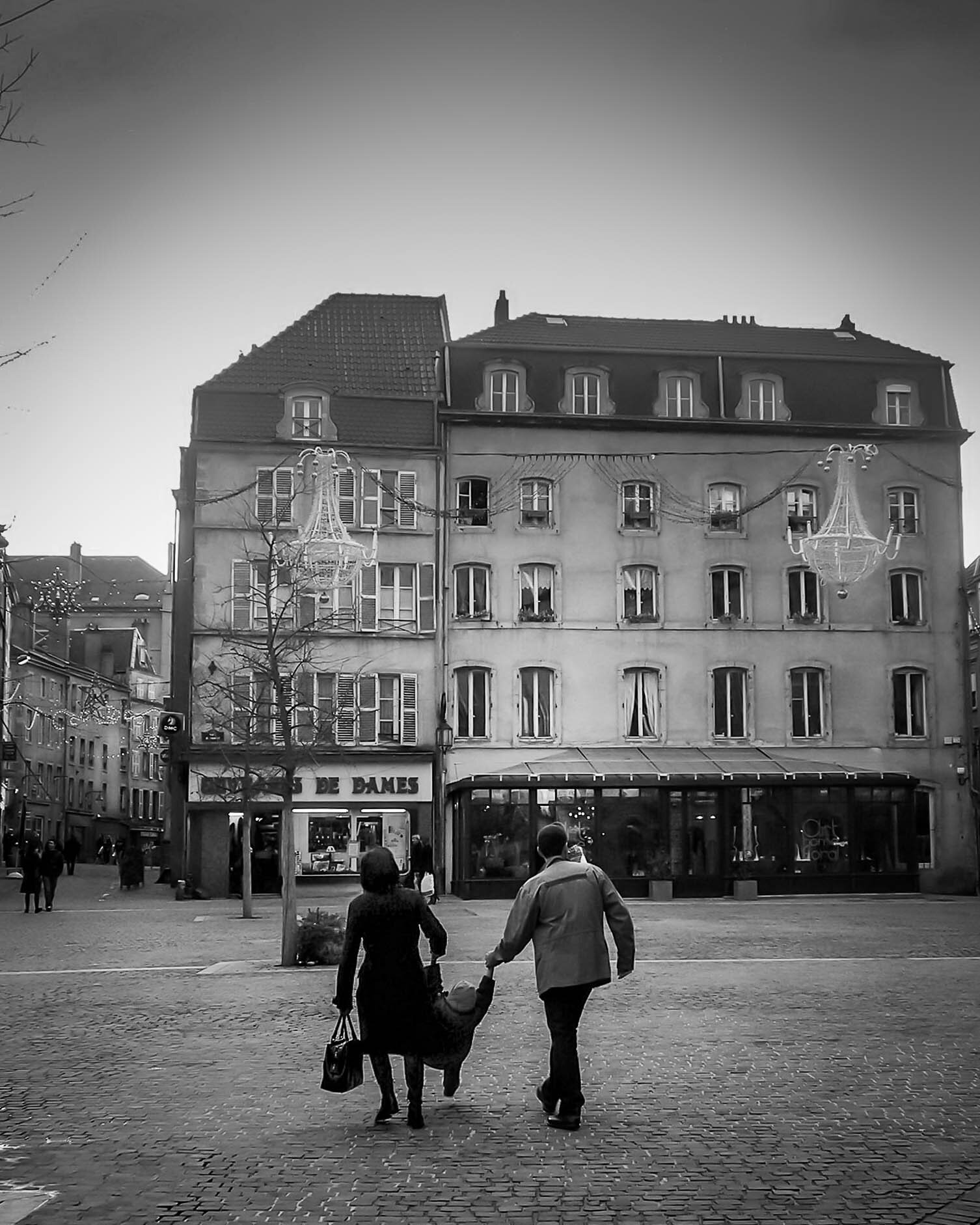 Couple swinging child, Strasbourg, France.