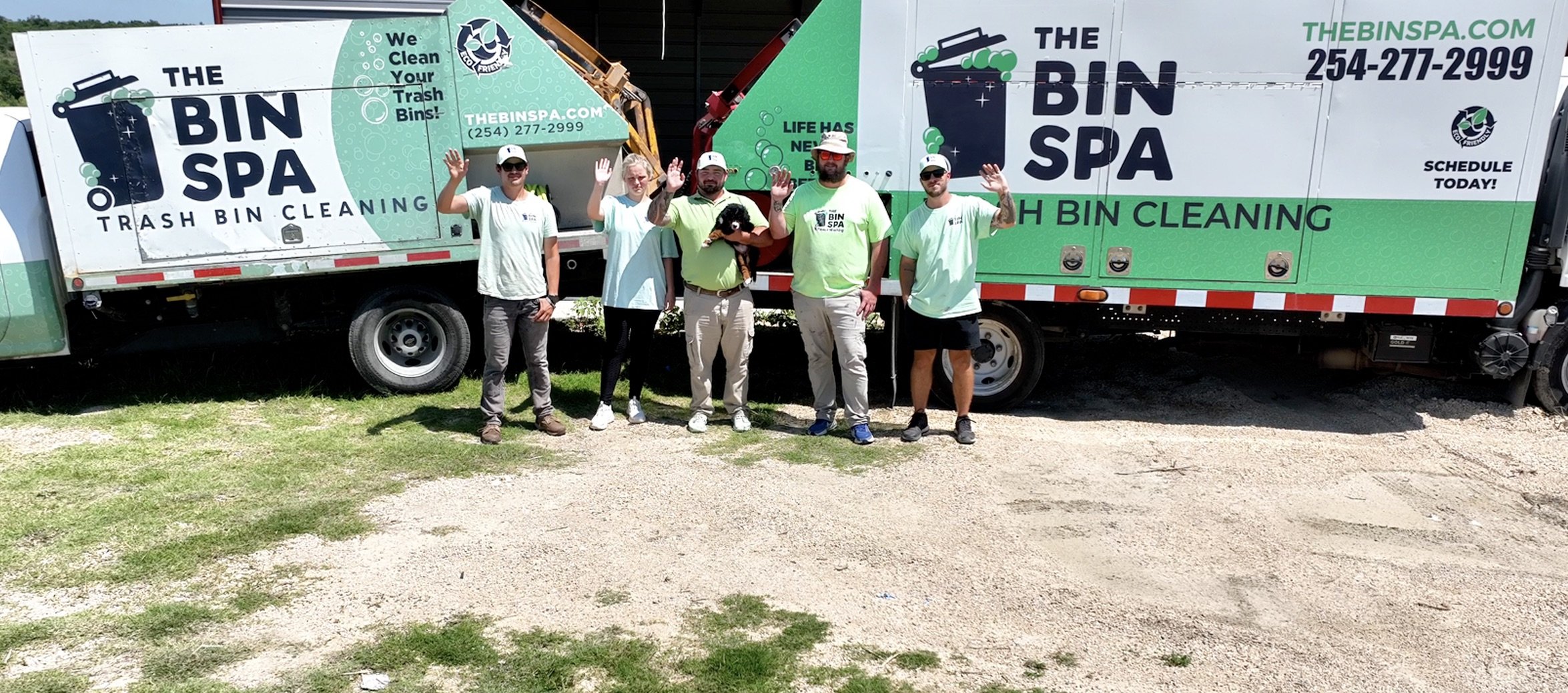The Bin Spa team posing in front of their trash can cleaning trucks at their garage in Salado Texas from a drone.