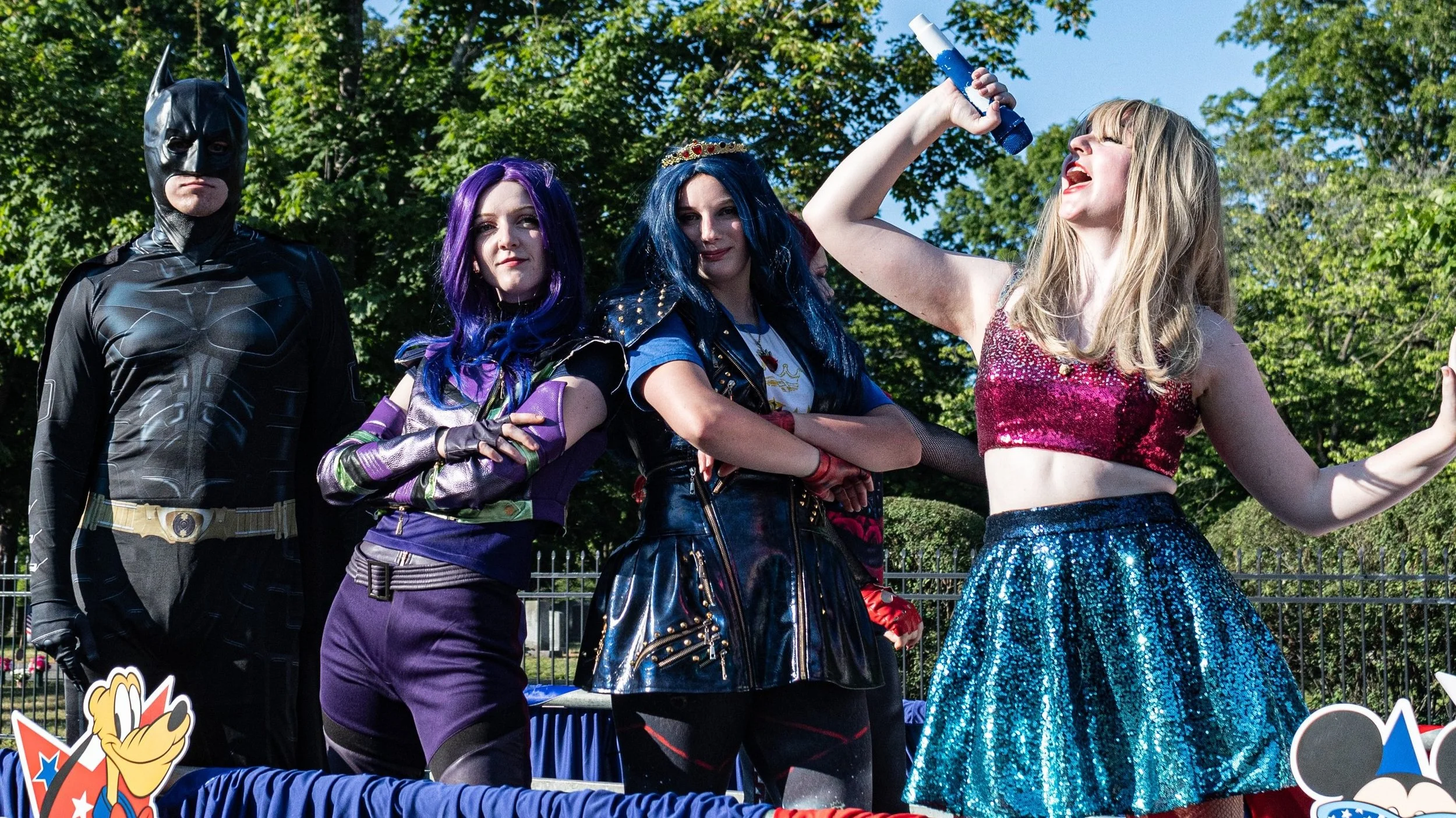 Villain Kids, Eras Queen, and Bat Hero Party Characters on a float in a fourth of july parade