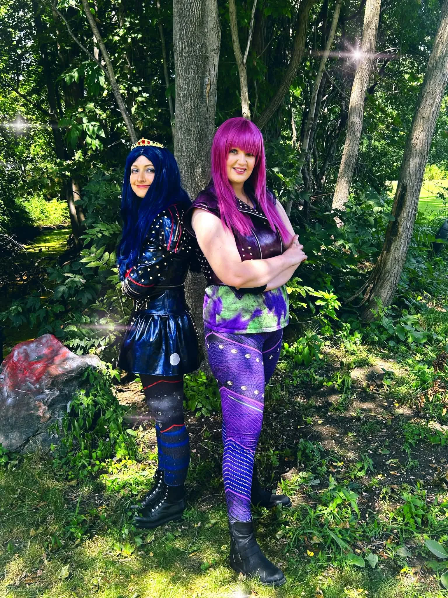 Teen Villain party characters posing outdoors in front of green bushes.