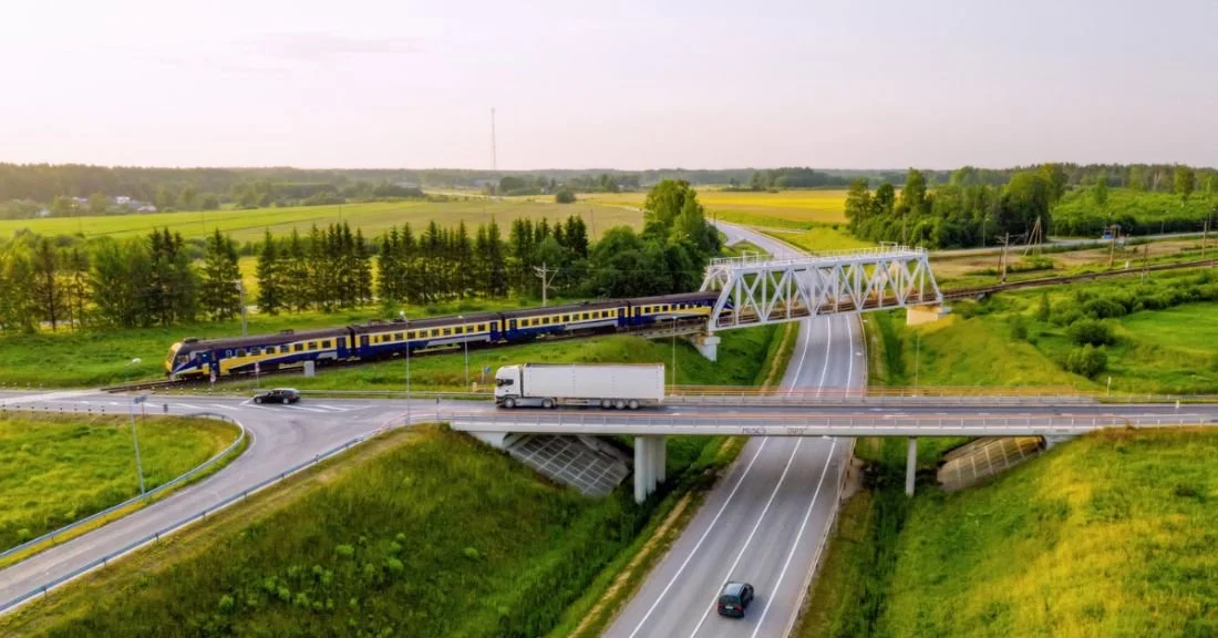 Aerial top view of a multi-level highway and railroad crossing. Source: iStock