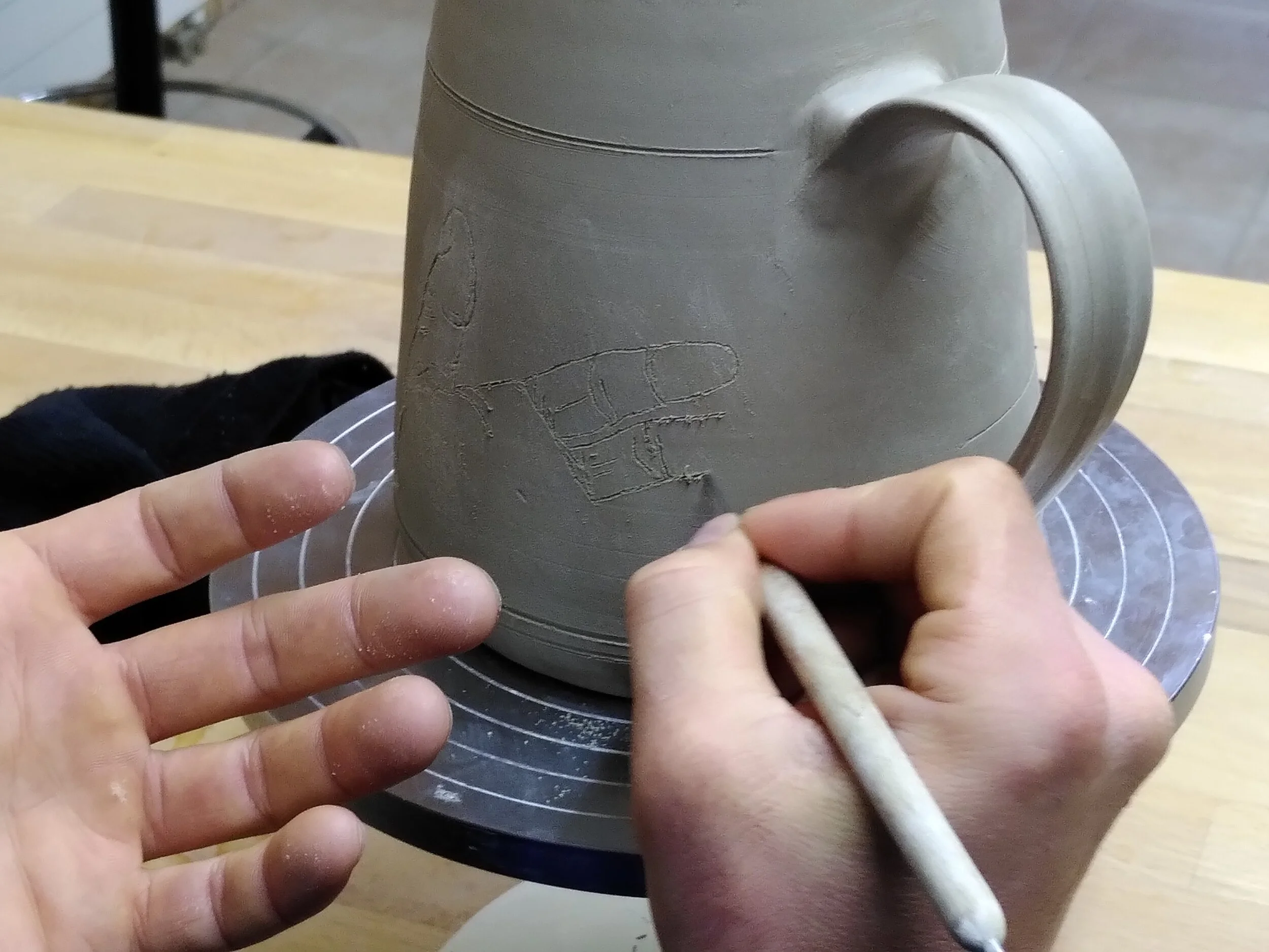 gravure sur une cruche (collaboration entre la potière et le participant)