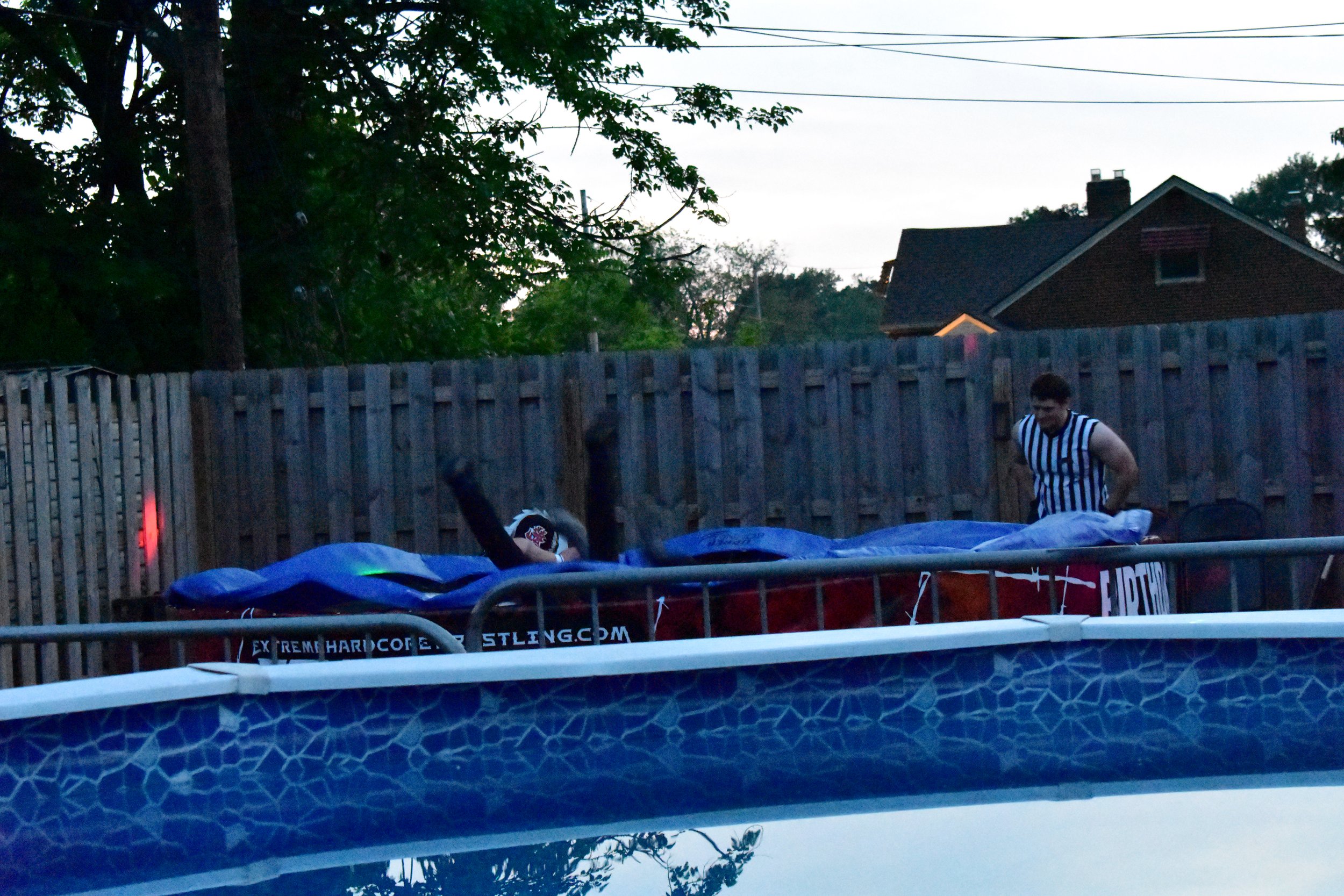 Backyard wrestling setup with a pool and referee
